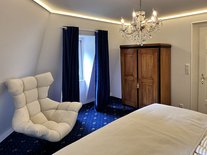 Suite Nachtigall mit komfortablem Designersessel, Kleiderschrank und warmem Lichtambiente