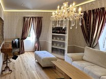 Wohnzimmer der Suite Nachtigall im Schloss Seeburg mit Kronleuchter, Sofa, edlen Vorhängen und historischem Ambiente.