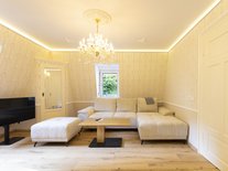 Wohnzimmer der Suite Nachtigall mit Sofa, Tisch und Fernseher im Schlössle Seeburg