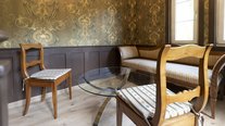 Das hübsche Turmzimmer bietet eine Sitzbank, zwei bequeme Stühle und einen Tisch – ideal für romantische Frühstücke.