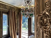 Turmzimmer der Suite Nachtigall im Schloss Seeburg mit Barocktapeten, Kronleuchter und Engelsmalerei an der Decke.