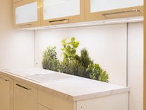 Moderne, helle Küche mit weißen Hochglanzfronten, Backoffen, Abzugzhaube, Blick ins Esszimmer.