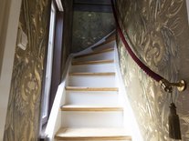 Turmzimmer der Suite Nachtigal mit elegantem Doppelbett und Kronleuchter im Schlössle Seeburg